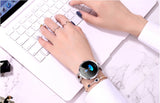 Smartwatch on a wrist with a laptop in the background